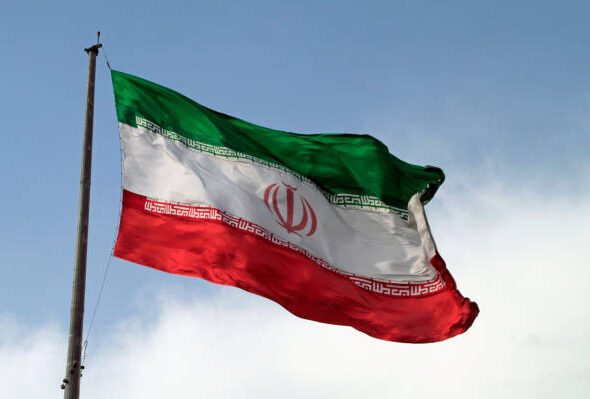 A big flag of Iran waving in the wind in Tehran, Iran.